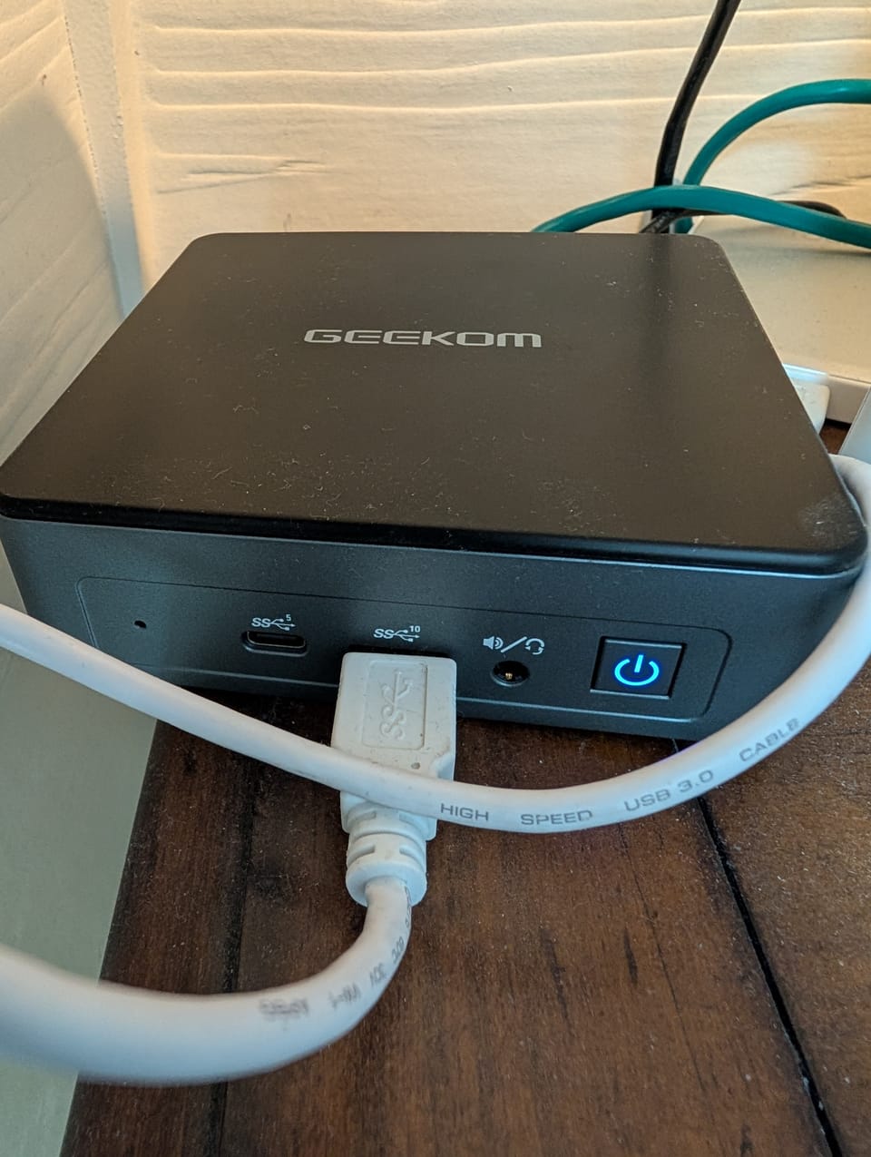 GEEKOM computer with network and USB cables plugged into it